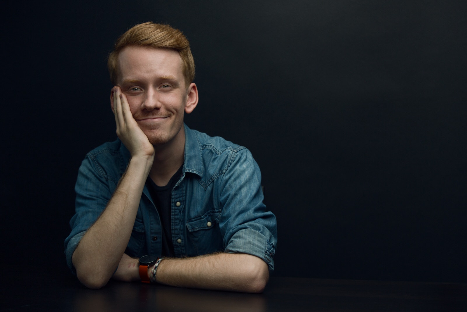 Headshot of redhead male actor against a black backdrop